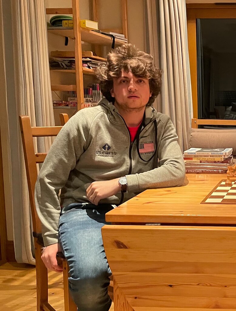 Young pensive man sitting and playing chess online